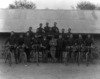 [Royal Irish Constabulary committee members and Mr. W. Gamble, taken in front of a corrugated building]