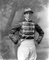 [Mr. Jack Widger in racing colours, three-quarter length studio portrait]