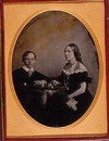 [Portrait of a woman and boy seated at a table playing chess]