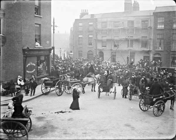 Funeral procession passing through Berkeley Street. View from Blessington Street of a crowd of mourners gathered around a horse-drawn funeral&nbsp;...