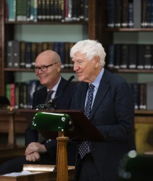 Joseph Hassett addressing an audience standing at a podium inside the NLI's Reading Room