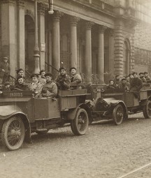 A black and white photo of two car loads of Black and Tans leaving a building on Amiens Street 