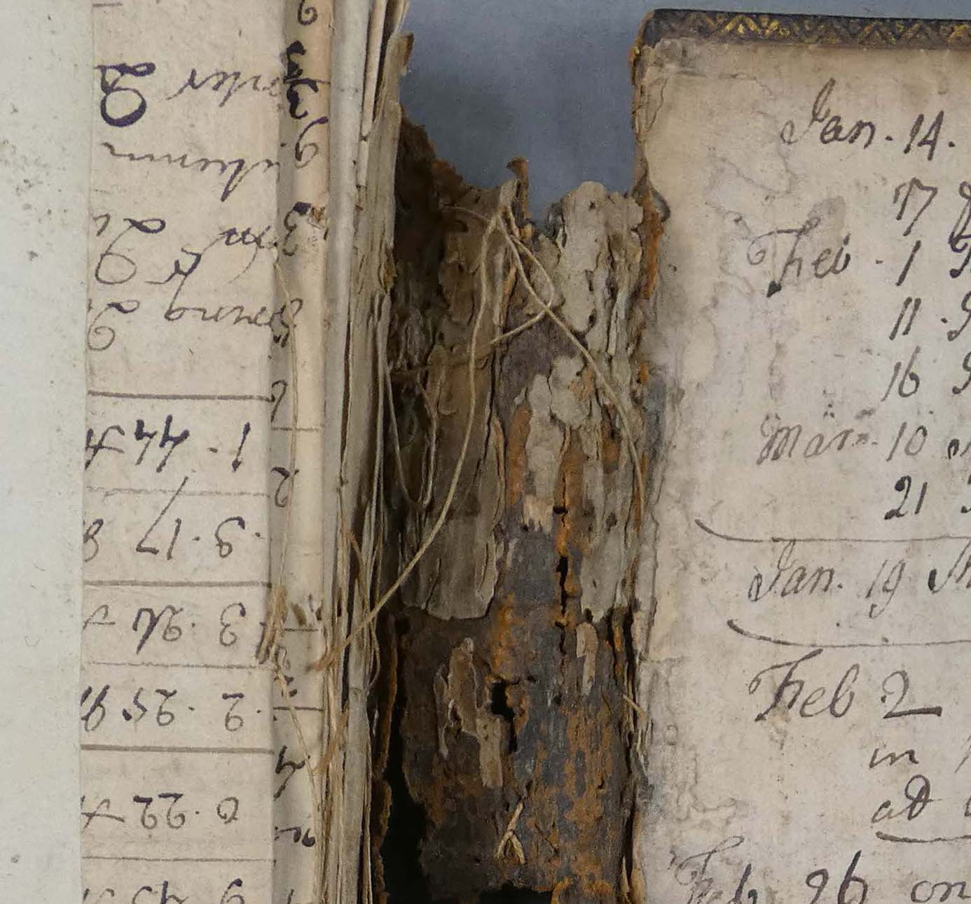 close up photograph of damaged and worn book binding with loose threads