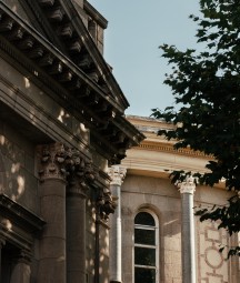 Exterior photograph of NLI's Main Library Building including tree and windows in shadow