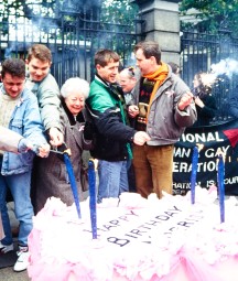 A group of protestors light a giant birthday cake outside the Government building gates