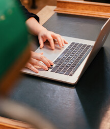 Person's hands typed on a computer keyboard
