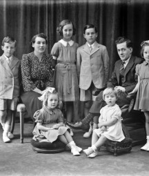 Black and white photograph depicting a family group with several children