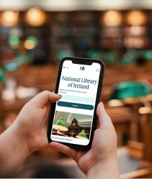 Close up a woman holding an iPhone browsing the NLI's website inside of the Reading Room