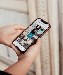 A woman browsing the NLI's Instagram feed on her iPhone