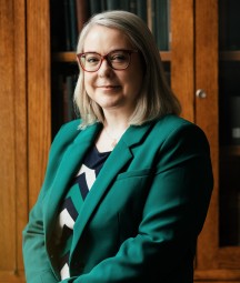 Image of Director in office with bookshelf in background