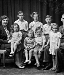 Black and White studio portrait of the Phelan family, featuring both parents and 7 children, ranging in age from about 3 to 10 years of age.  