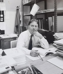 Black and white photograph of a man sitting at a desk