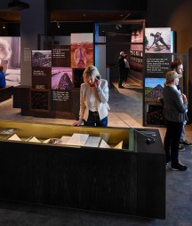 Interior exhibition space with visitors viewing items on display at Seamus Heaney Listen Now Again exhibition