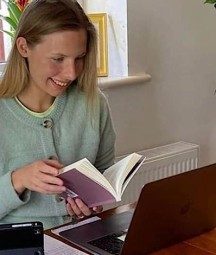 image of blonde haired woman looking at computer screen 