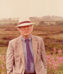 Heaney in a suit standing in a bog