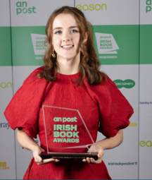 molly in a red dress holding a book award