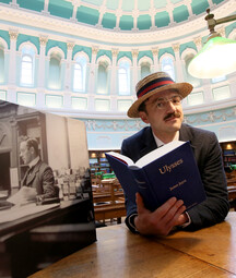 Man dressed as James Joyce reading Ulysses in the reading room