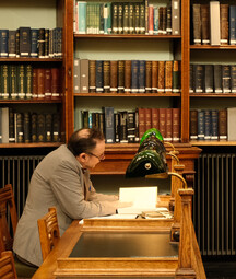 man at reading room table