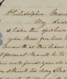Image of a handwritten letter with an eagle and American flag pendant. 