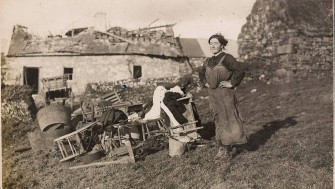 An old photograph of Ms. Brown surrounded by her belongings, outside her home in Meelin, Co. Cork, that was destroyed in a reprisal attack by the Black and Tans. 7 January 1921