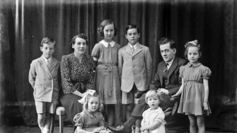 Black and white photograph depicting a family group with several children