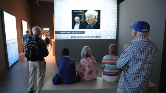 image of a group both sitting and standing enjoying the Seamus Heaney exhibition