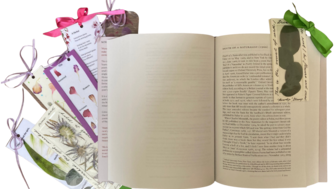 An open book lies flat with blank pages visible, surrounded by several decorative bookmarks. The bookmarks feature botanical illustrations, pressed flowers, and soft pastel designs, each tied with colorful ribbons in pink, purple, and green. One bookmark is tucked into the book, while others fan out to the side, creating a delicate, floral-themed arrangement.