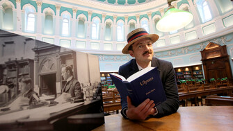 Man dressed as James Joyce reading Ulysses in the reading room