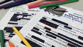 Two pages of poetry with blacked out words with pencils and pens around the poetry