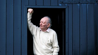 brian friel at his boathouse, standing in the doorway