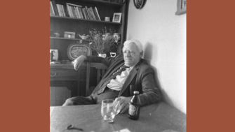 A black and white photo of Patrick Heaney sitting at his kitchen table