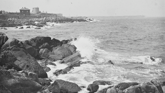 A black and white photo of waves crashing against the rocks in Dublin bay.