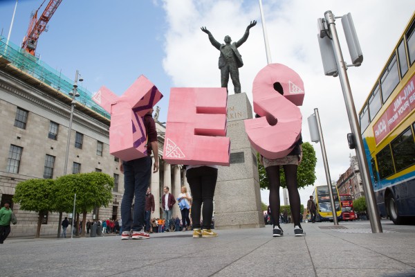 People holding the letters Y-E-S