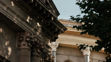 Exterior photograph of NLI's Main Library Building including tree and windows in shadow