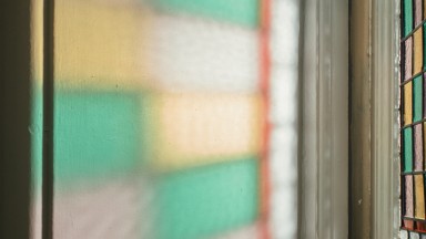 Light coloured by a stained glass window refracted on a wall in the NLI's Main Library Building