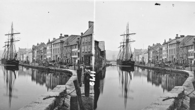 Double image of a boat on a canal