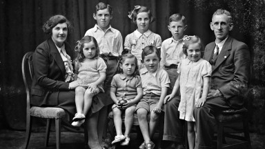 Black and White studio portrait of the Phelan family, featuring both parents and 7 children, ranging in age from about 3 to 10 years of age.  