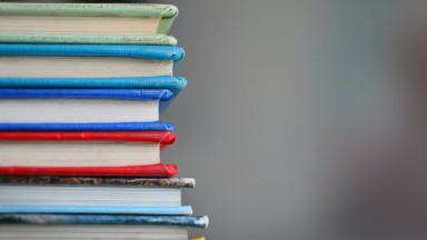 The open sides of a stack of colourful books 