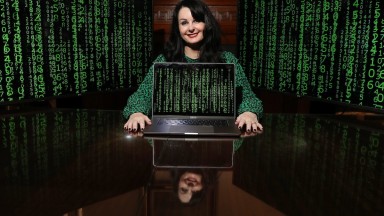 Image of Marian Keyes with laptop and coding background