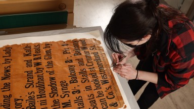 Image of woman preserving old poster
