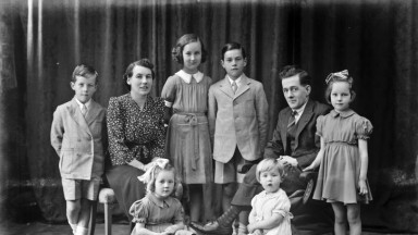 Black and white photograph depicting a family group with several children