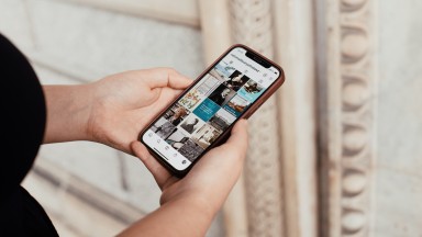 A woman browsing the NLI's Instagram feed on her iPhone