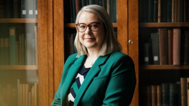 Image of Director in office with bookshelf in background