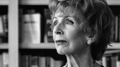 Portrait photograph of Edna O'Brien in front of bookshelves