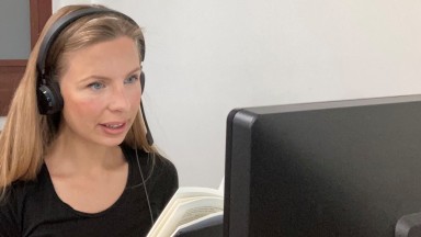 Woman with blonde hair looking at computer screen