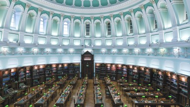 Empty reading room with rows of desk and large blue and white domed ceiling
