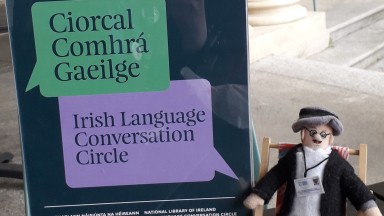 Joyce finger puppet sitting on steps outside the nLI