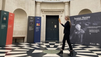 Colour photograph of woman walking through circular hallway.