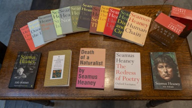 Photograph showing a wooden table of books. 
