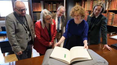 NLI and UCD staff around book